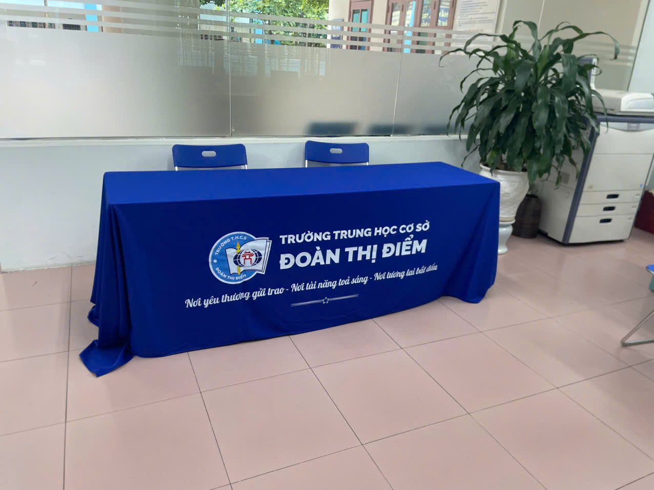 Khăn trải bàn in logo trường THCS Đoàn Thị Điểm, vải xanh dương trùm kín chân
